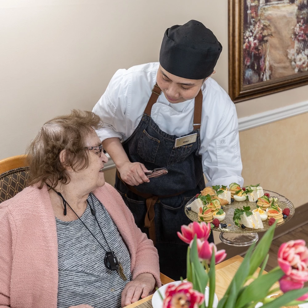 A staff member offering food to a resident.