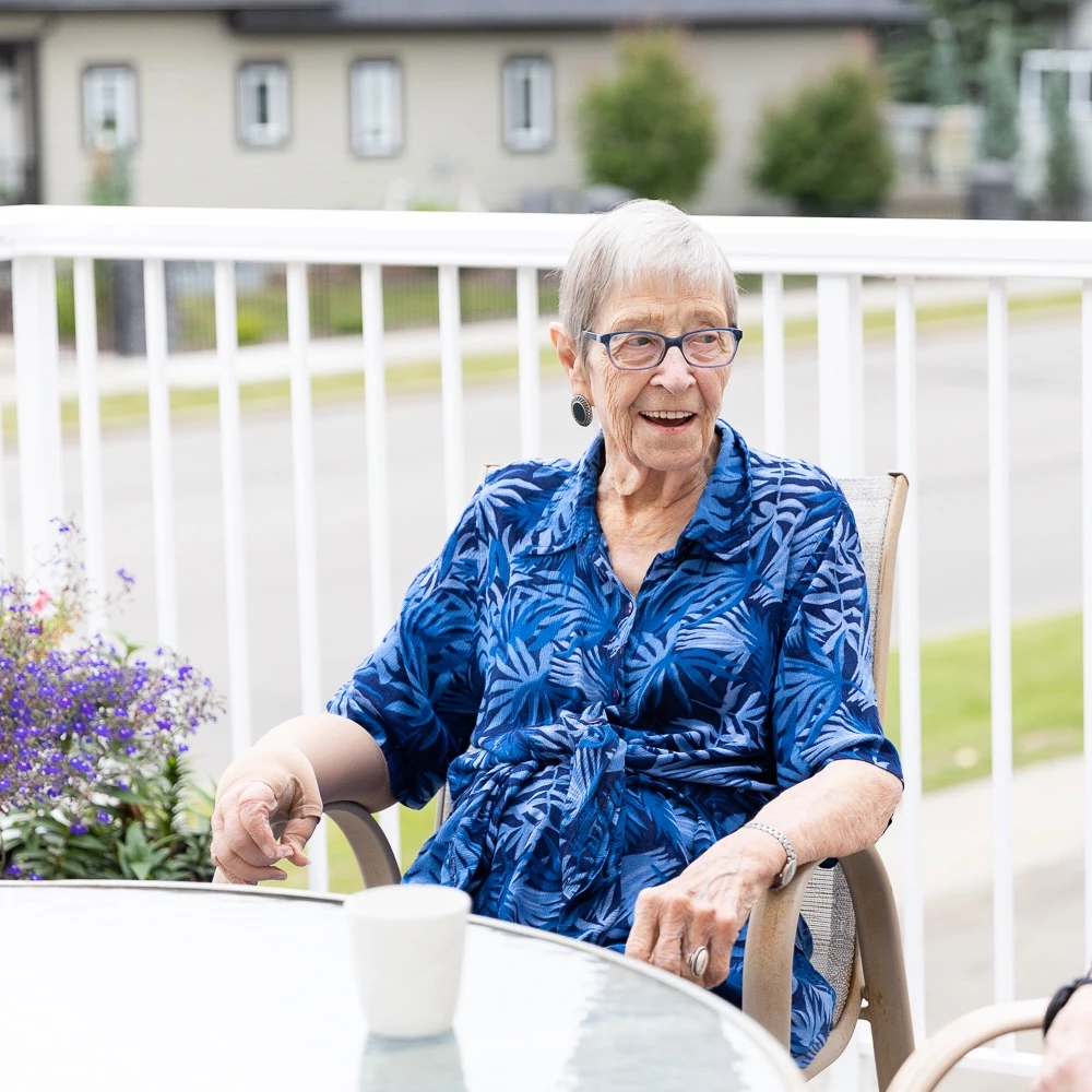 Senior woman wearing blue shirt sitting on patio